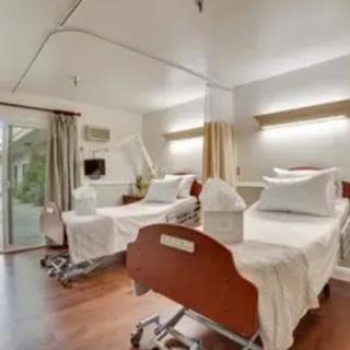 A hospital room with two beds, designed for patient care in a clean medical environment.