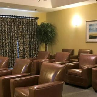 A cozy waiting room with comfortable leather chairs and warm lighting.