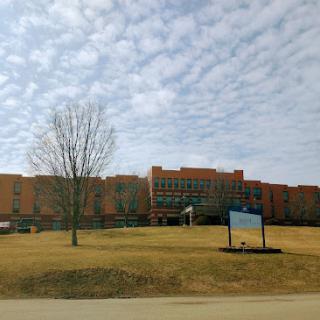 A view of a large institutional building against a cloudy sky.