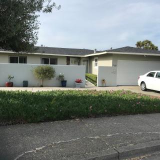 A suburban house with a driveway and a parked car.