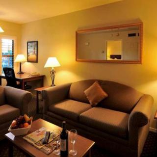 A warm and cozy living room with comfortable sofas, lamps, and a decorative mirror.