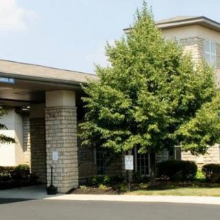 A view of a building's entrance with trees and landscaping.