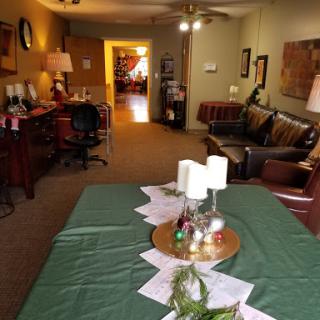 A cozy living space featuring a green tablecloth, decorative candles, and comfortable seating.