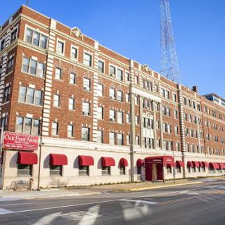 A classic brick building featuring red awnings along the street.