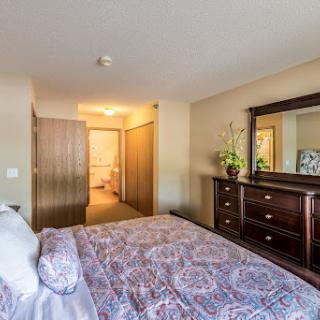 A cozy bedroom featuring a beautifully made bed and elegant wooden furniture.