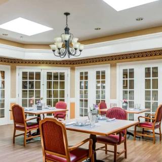 A spacious dining room with elegant furnishings and plenty of natural light.