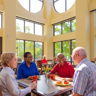 A group of seniors enjoying a meal together in a bright, inviting dining space.