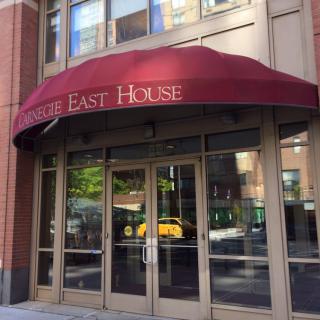 Entrance to a building with a red awning labeled 'Circle East House'.