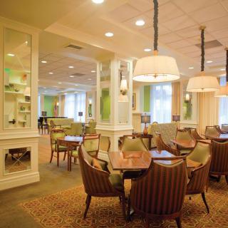 A warmly lit dining area with elegant decor and seating arrangements.