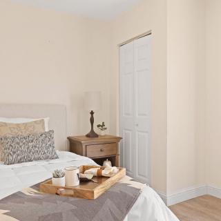 A cozy bedroom with a bed, nightstand, lamp, and decorative tray.