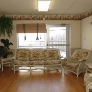 A cozy living room with floral furniture and wooden flooring.