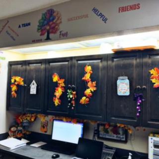 An office space decorated with autumn-themed garlands and wall art, creating a cozy and festive atmosphere.