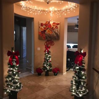 A beautifully decorated entryway adorned with Christmas trees and twinkling lights, creating a warm holiday ambiance.