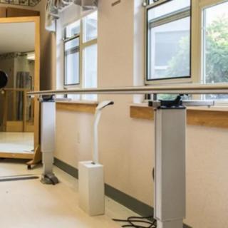 A physical therapy room equipped with parallel bars for rehabilitation exercises.