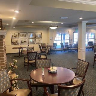A spacious dining area with tables and chairs, featuring elegant decor and warm lighting.