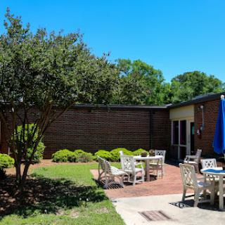 A sunny outdoor patio area with comfortable seating and well-maintained greenery.