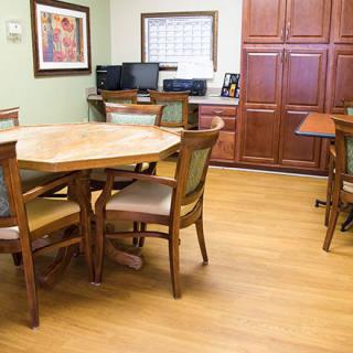 A small meeting room with a wooden table, chairs, and office equipment.