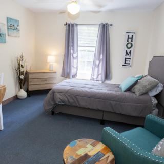 A cozy and modern bedroom with a comfortable bed, armchair, and stylish decor.