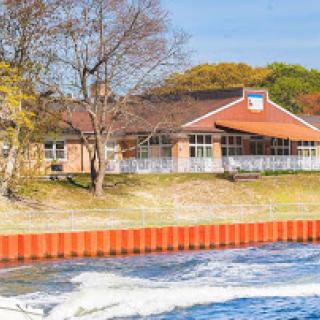 A charming waterfront building surrounded by trees, offering a serene view of the water.