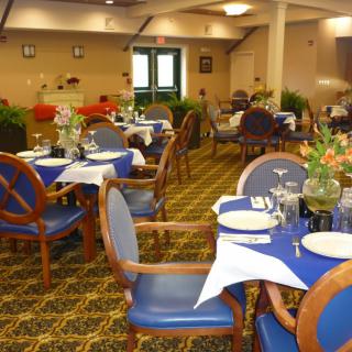 A well-arranged dining area with blue-themed table settings and comfortable seating.