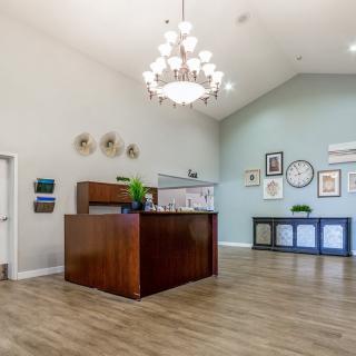 A modern reception area featuring a wooden desk and decorative chandelier.