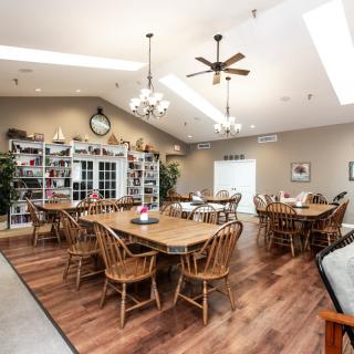 A cozy dining room with wooden furniture and ample natural lighting.