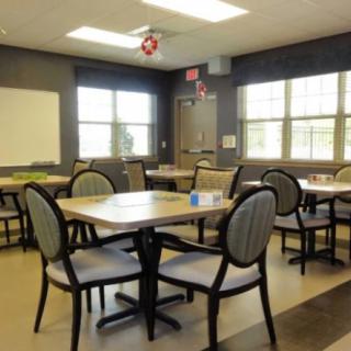 An empty dining room with tables and chairs arranged neatly.