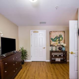 A cozy living room with a television, wooden floors, and tasteful decor.