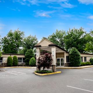 A welcoming entrance to a hospitality establishment surrounded by lush greenery.