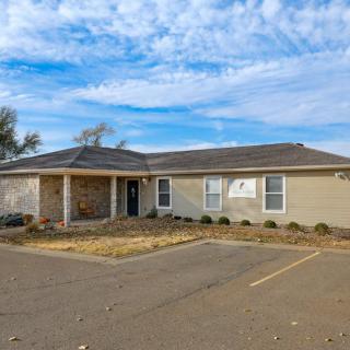 A single-story suburban house with a driveway and clear skies above.