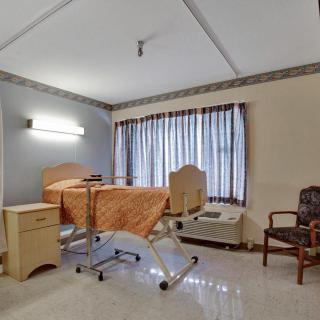 A hospital room with a bed, medical equipment, and seating area.