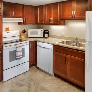 A modern kitchen with wooden cabinets and various appliances.