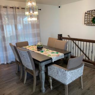 A cozy dining room setup featuring a wooden table, stylish chairs, and elegant lighting.