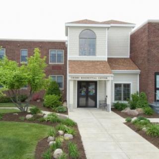 A well-maintained building entrance with landscaped surroundings.