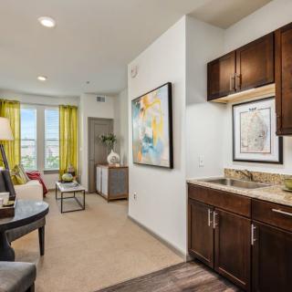 A modern living space featuring a kitchenette and vibrant decor.