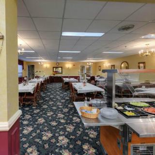 An interior view of a dining room with tables and a buffet station.