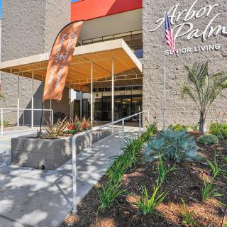 A modern building entrance with landscaping and clear signage for Arbor Palm.