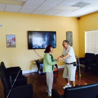 Two seniors dancing together in a living room.