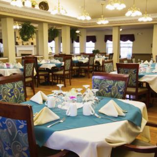 An elegant dining room setting with neatly arranged tables and chairs, featuring formal table settings.