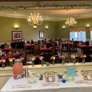 A decorated banquet hall with chandeliers and a refreshment table set up for an event.