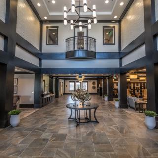 A spacious and elegantly designed lobby featuring a grand chandelier and modern decor.