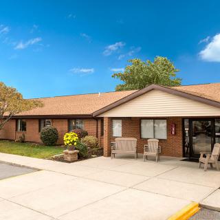 A brick building with a welcoming entrance and landscaped surroundings.