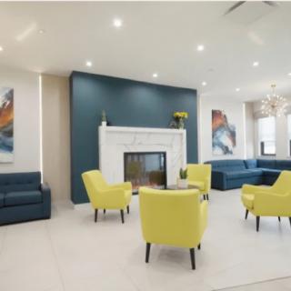 A modern living room with yellow chairs, a fireplace, and blue accent walls.
