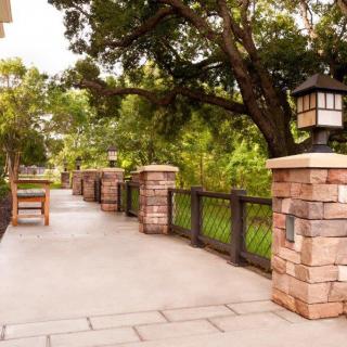 A scenic walkway surrounded by lush greenery and stone lanterns.