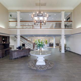 A spacious hotel lobby with elegant decor and a large chandelier.