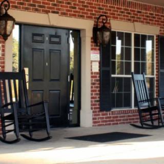 A cozy front porch with brick walls and rocking chairs.