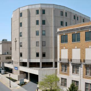 A modern parking garage attached to a commercial building in an urban setting.
