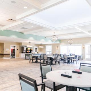 A modern, spacious dining area designed for community gatherings, featuring elegant furniture and ample natural light.