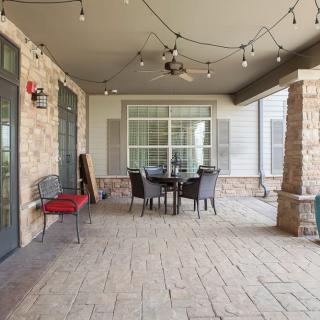 A cozy outdoor patio with seating and string lights on a covered porch.