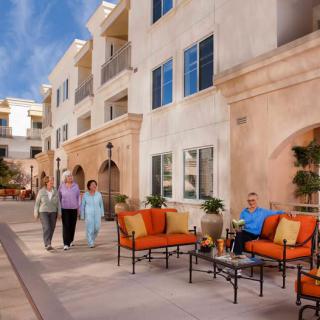 Seniors enjoying a leisurely day at a retirement community, featuring comfortable outdoor seating and a pleasant atmosphere.